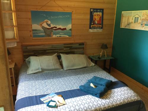 a bedroom with a bed with blue towels on it at Maison de Lege in Lège-Cap-Ferret