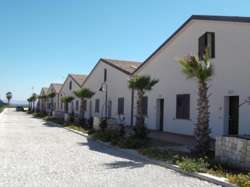 eine Reihe von Häusern auf einer Straße mit Palmen in der Unterkunft Case Vacanze Bellavista in Realmonte