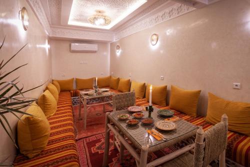 a living room with a table and yellow pillows at Riad Salman in Marrakech