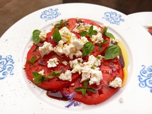 a plate of food with tomatoes and cheese on it at Mas Lo Faix in Saint-Laurent-de-Cerdans