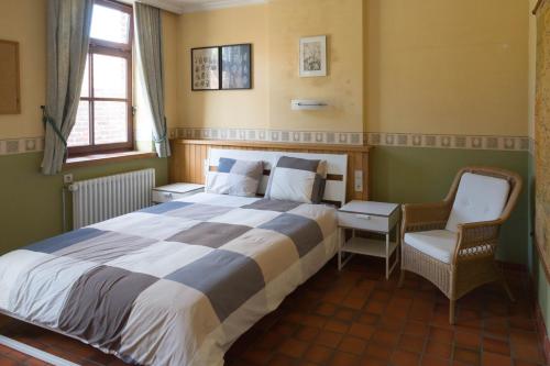 a bedroom with a large bed and a chair at Glabbeek-hoeve in Geetbets