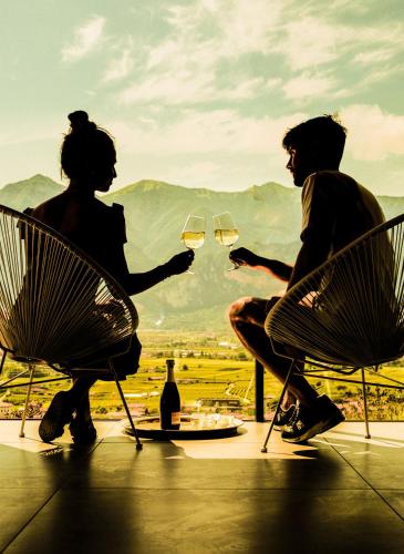 two people sitting in chairs holding glasses of wine at Gazzi Apartments 'Panoramic & Relaxing' in Arco