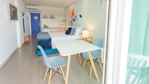 a bedroom with a bed and a table and chairs at Kembali Hotel Porto de Galinhas - Adults Only in Porto De Galinhas
