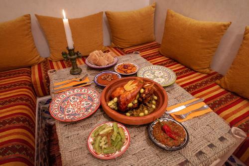 a table with plates of food on a couch at Riad Salman in Marrakech