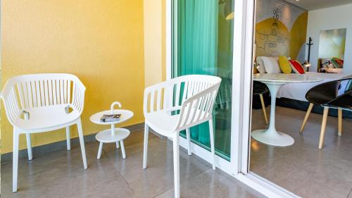 two white chairs and a table in a room at Kembali Hotel Porto de Galinhas - Adults Only in Porto De Galinhas