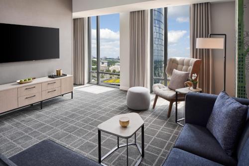 a living room with a couch and a tv at The Watermark Hotel in Tysons Corner