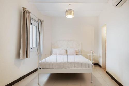 a white bed in a white room with a window at Stay U-nique Apartments Pasteur in Barcelona
