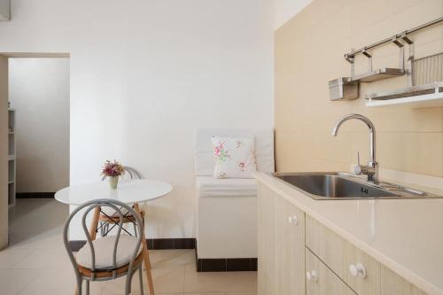 une cuisine avec un évier et une table avec une chaise dans l'établissement Stay U-nique Apartments Pasteur, à Barcelone