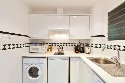 a white kitchen with a sink and a washing machine at Stay U-nique Apartments Passeig de Gracia II in Barcelona