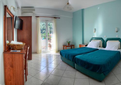 1 dormitorio con 1 cama con colcha azul en Nikas Villa Orange Apartments , en Parga