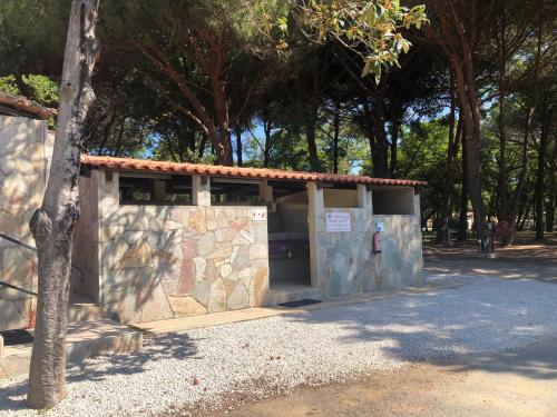 a stone building with a tree in front of it at Camping Dolce Vita in Calvi