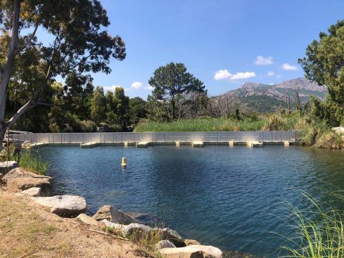 a pool of water with a bridge in the background at Camping Dolce Vita in Calvi