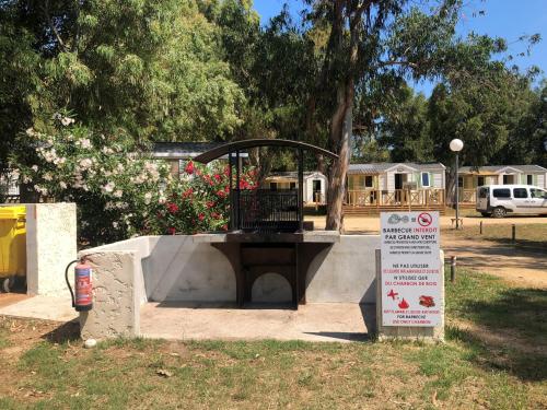 a fire hydrant in a park with a sign at Camping Dolce Vita in Calvi