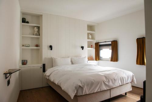 sypialnia z białym łóżkiem i oknem w obiekcie Hotel Riga w Antwerpii