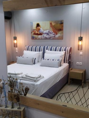 um quarto com uma cama grande e uma pintura na parede em Katsenos studios em Nikiana