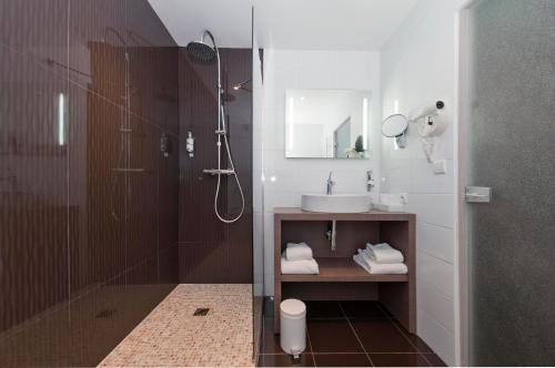 a bathroom with a shower and a sink at Quintessia in Orvault