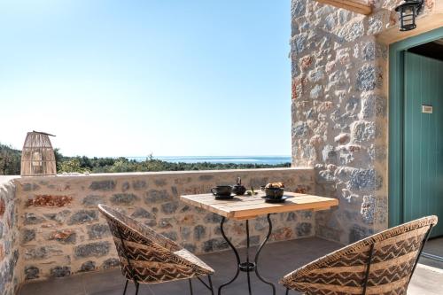 a table and chairs on a patio with a view at The Olive Yard in Gythio