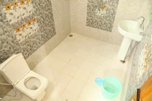 a small bathroom with a toilet and a sink at Oak Essence in Mukteshwar