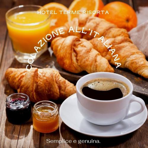 een kopje koffie en croissants op een tafel bij Hotel B&B Risorta in Abano Terme