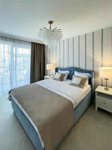 um quarto com uma cama grande e um lustre em Luksusowy Apartament Blue11 em Międzyzdroje