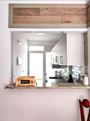 a kitchen with white cabinets and a large window at Casa Martín in Avila