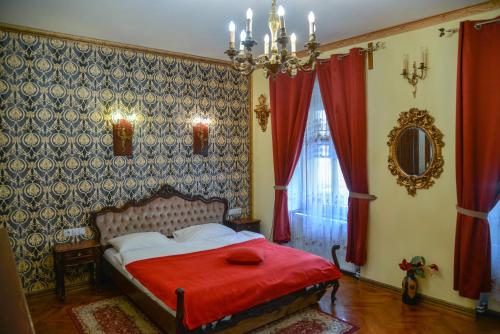 ein Schlafzimmer mit einem Bett mit einer roten Decke in der Unterkunft History Apartments Cetății in Sibiu