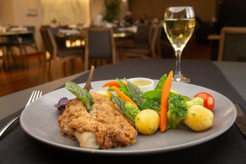 a plate of food with chicken and vegetables on a table at Hotel Filmar in Toruń