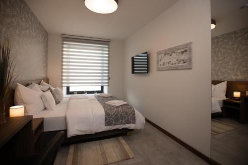 - une chambre avec un grand lit et une fenêtre dans l'établissement Hochnegger Apartments, à Eibiswald