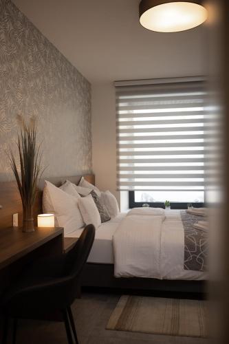 a bedroom with a bed with a window and a chair at Hochnegger Apartments in Eibiswald