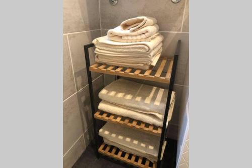 a stack of towels on a rack in a bathroom at Laon : « Suite privée au pied de la Cathédrale » in Laon