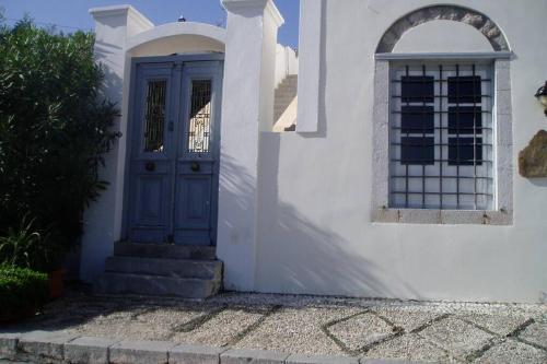 a white house with a blue door and a window at Relax & Enjoy in Spetses