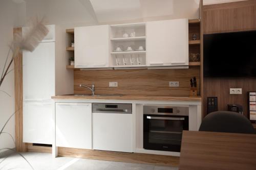 a kitchen with white cabinets and a sink at Hochnegger Apartments in Eibiswald