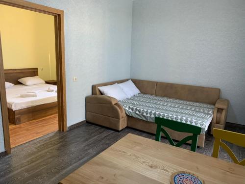 a room with a couch and a bed and a mirror at Royal Cottage in Ureki