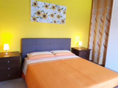 a bedroom with a bed with two nightstands and two lamps at Oltremare in Vignacastrisi