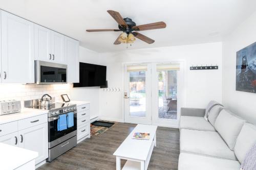 a white kitchen with a couch and a ceiling fan at Viking Lodge 109 - Viking Venue in Telluride