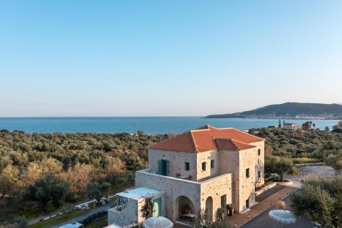 una vista aérea de un edificio con el océano en el fondo en The Olive Yard, en Gythio