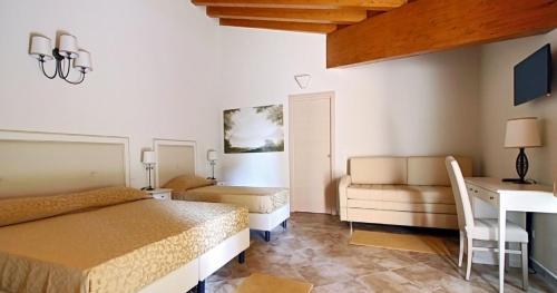 a bedroom with a bed and a desk and a table at Hotel Villa Borghesi in Corte dei Cortesi