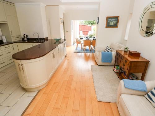 een keuken en een woonkamer met een houten vloer bij The Headlands - Gower in The Mumbles