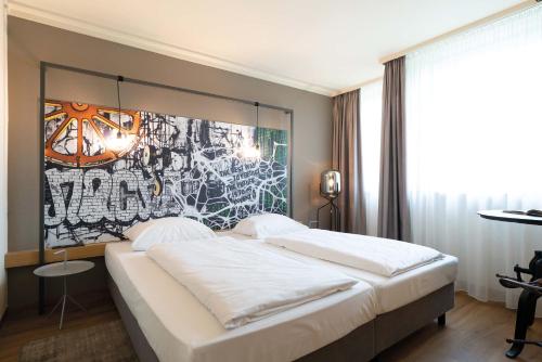 a bedroom with a bed with a painting on the wall at Seminaris Hotel Bad Boll in Bad Boll