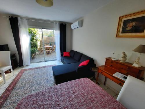 sala de estar con sofá azul y mesa en Coquet T2 ,terrasse,parking ,4 kms d Avignon, en Villeneuve-lès-Avignon