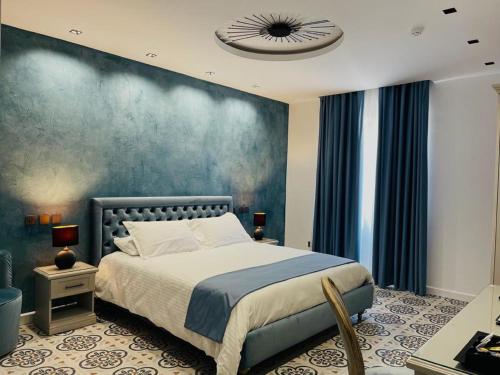 Casa Reale Boutique Hotel في فاليتا: غرفة نوم بسرير وجدار ازرق