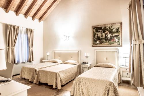 um quarto com duas camas e um quadro na parede em Hotel Villa Borghesi em Corte dei Cortesi