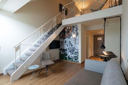 a living room with a staircase and a table at Seminaris Hotel Bad Boll in Bad Boll