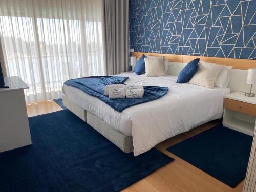 a bedroom with a large bed with two pillows on it at Buarcos Luxury Guest house in Figueira da Foz