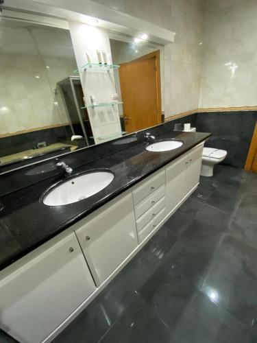 a bathroom with two sinks and a large mirror at Buarcos Luxury Guest house in Figueira da Foz