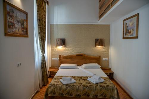 a bedroom with a bed with two towels on it at History Apartments Piata Mare in Sibiu