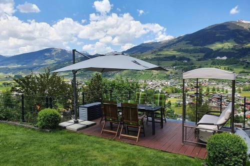 a patio with a table and chairs and an umbrella at Hinterreithlehen - Ferienwohnung am Bauernhof in Mittersill