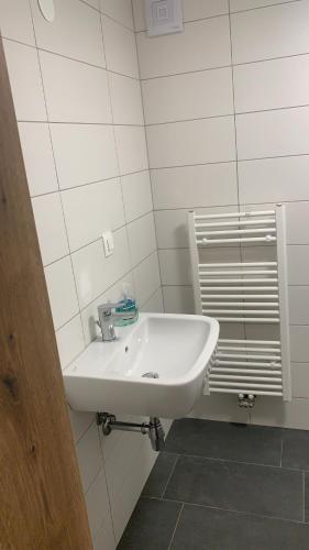 un lavabo blanco en un baño de azulejos blancos en Amazing apartment en Stari Trg pri Ložu