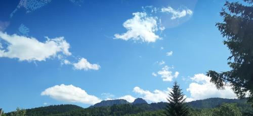 a blue sky with clouds and mountains in the background at Czarne jagody in Kościelisko
