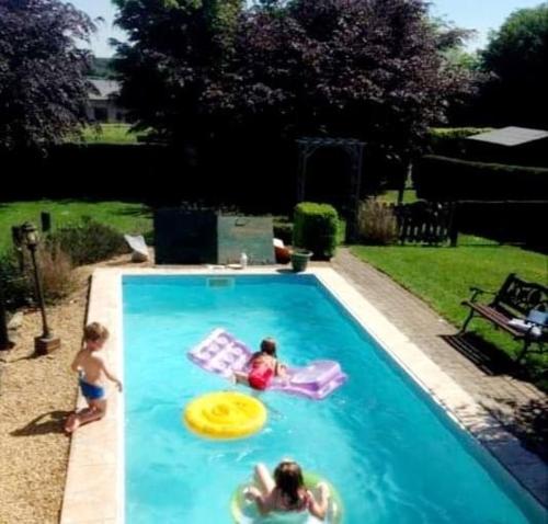 two girls playing with a frisbee in a swimming pool at Les MauLau'x in Sʼberchamp
